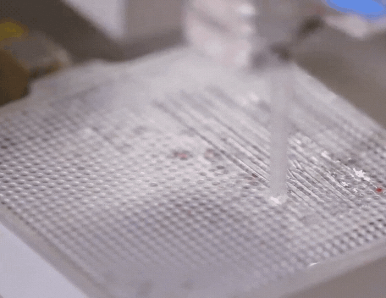 Gif of a printhead nozzle bioprinting a couple of layers of clear material in a square, followed by a zig-zag pattern in red